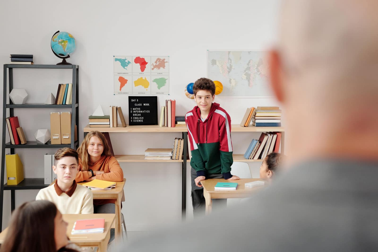 Students attentively listening in a classroom environment, promoting learning and engagement.